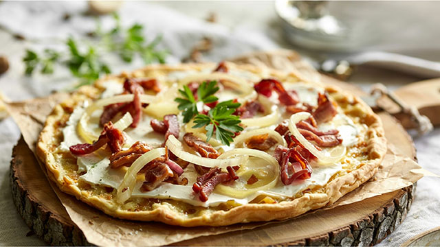 Frischer Flammkuchen mit Speck und Zwiebeln