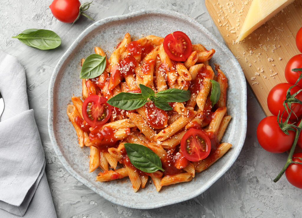 Penne Pasta mit Tomatensauce, frischen Tomaten und Basilikum